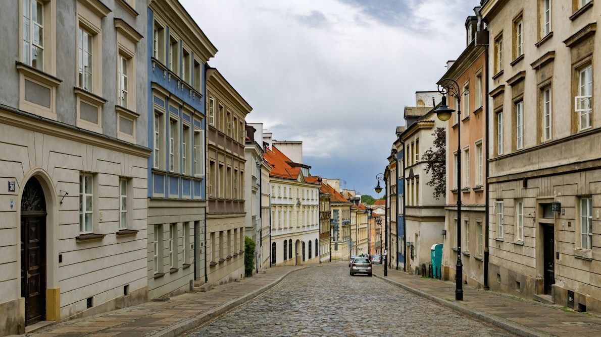 A cobblestone street lined with historic buildings in Warsaw Old Town