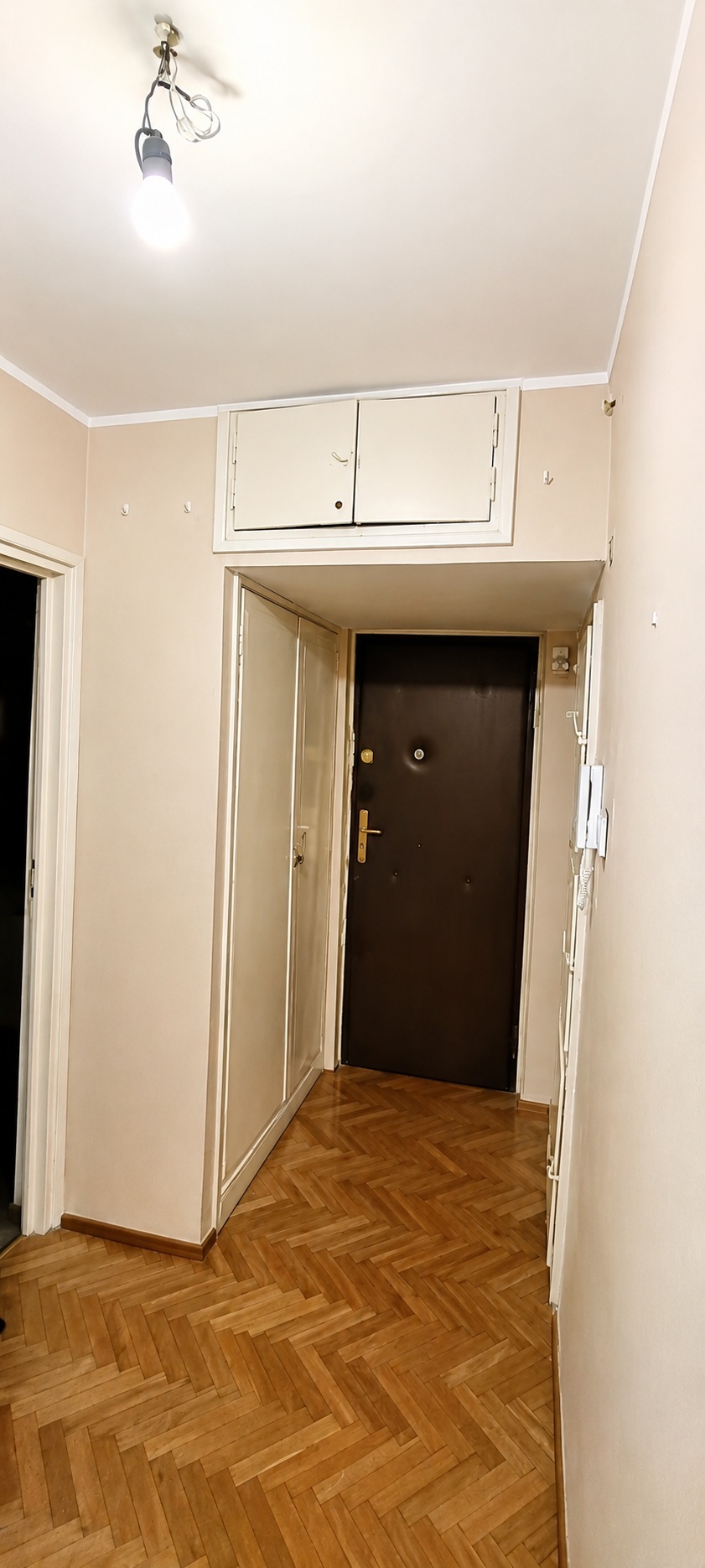 Hallway of the Wola apartment before renovation — dated finish