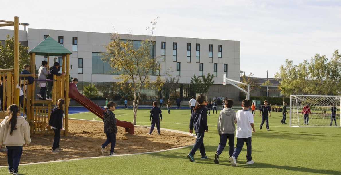 Children playing on a school playground and sports field during break at a Warsaw international school