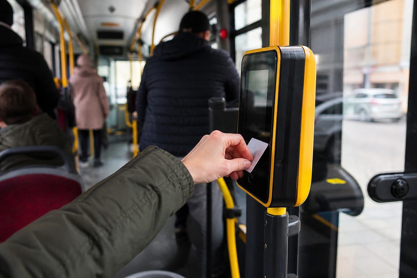 Passenger activating a public transport ticket inside a modern Warsaw city bus